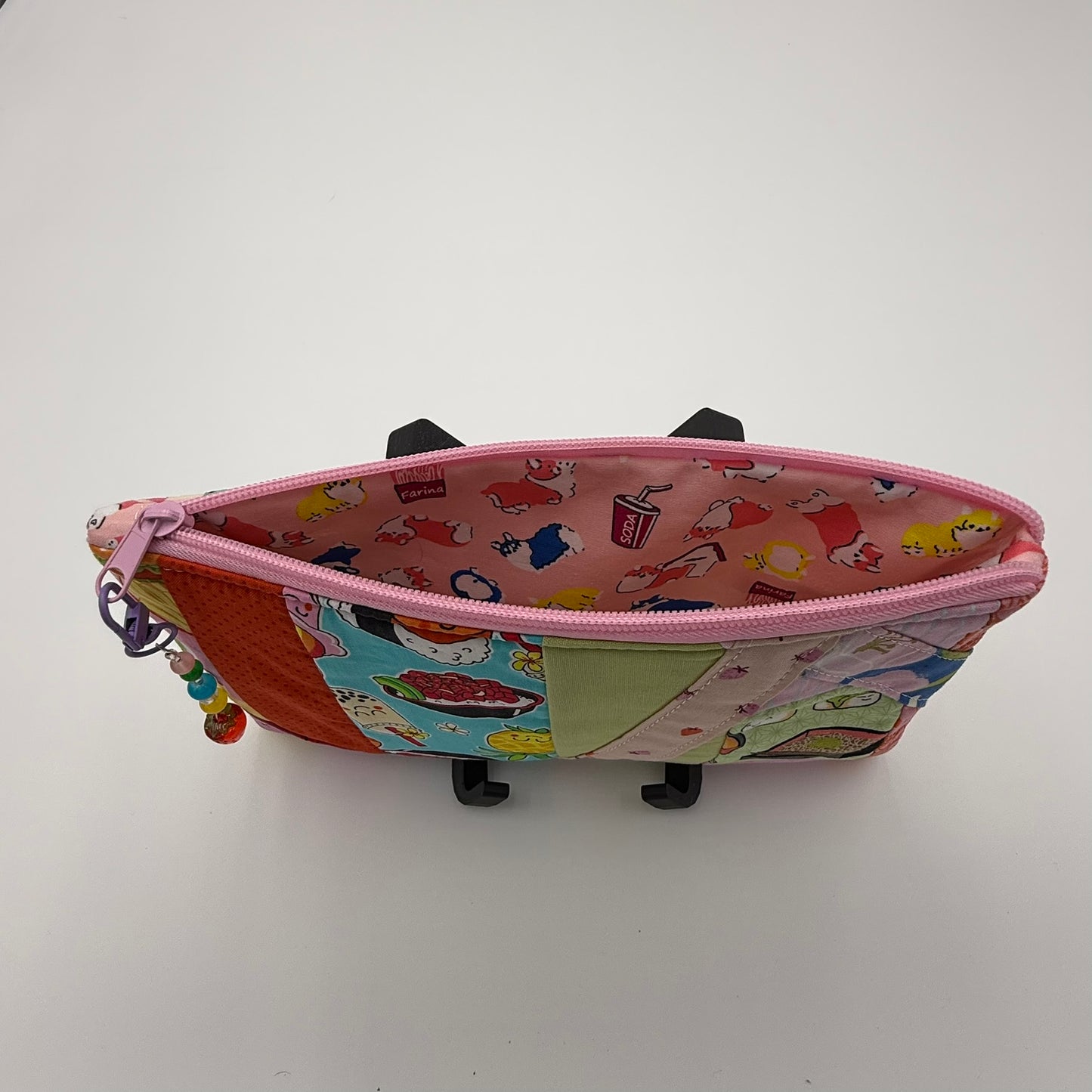 Handmade patchwork quilted zipper pouch with colorful fabric scraps