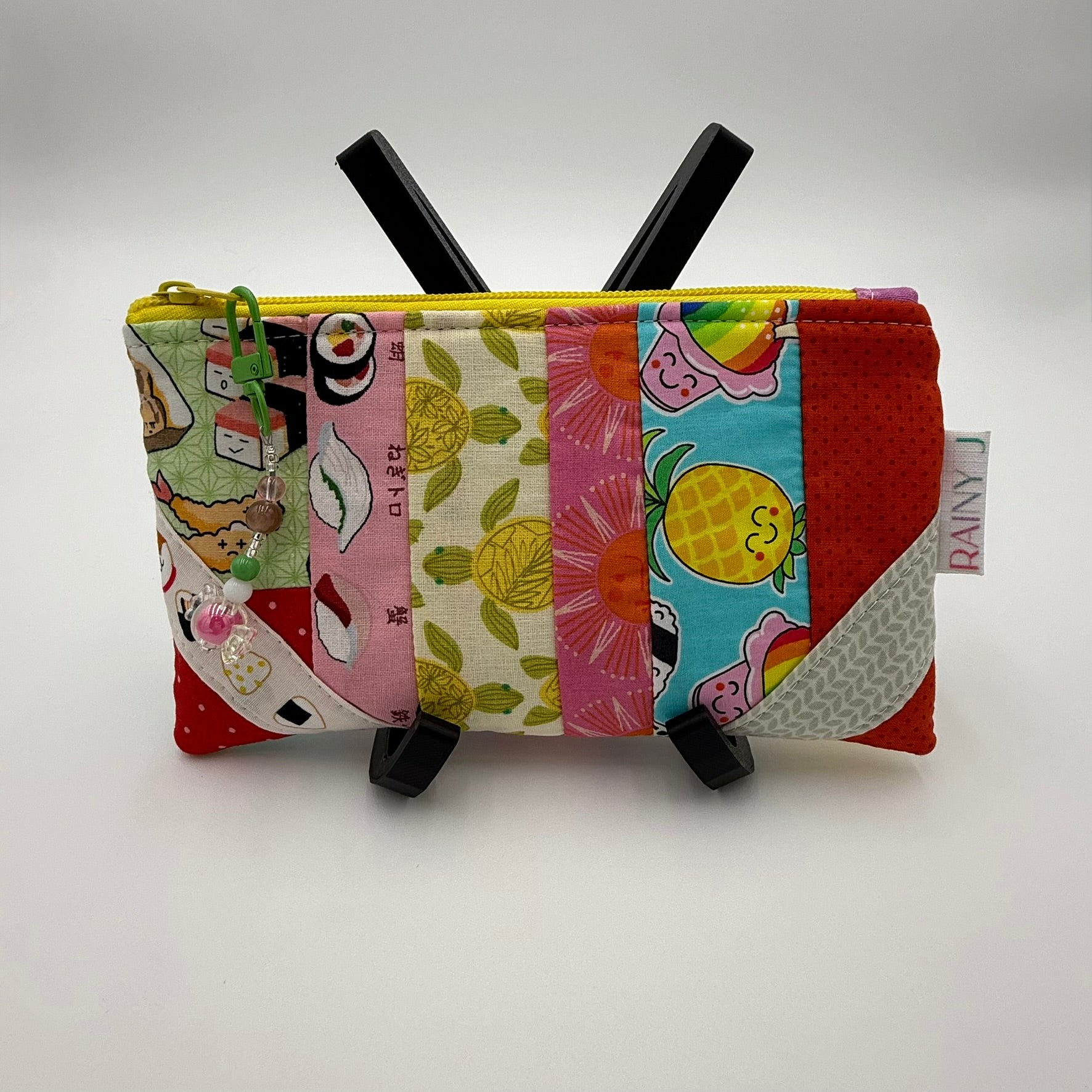 Handmade patchwork quilted zipper pouch with colorful fabric scraps