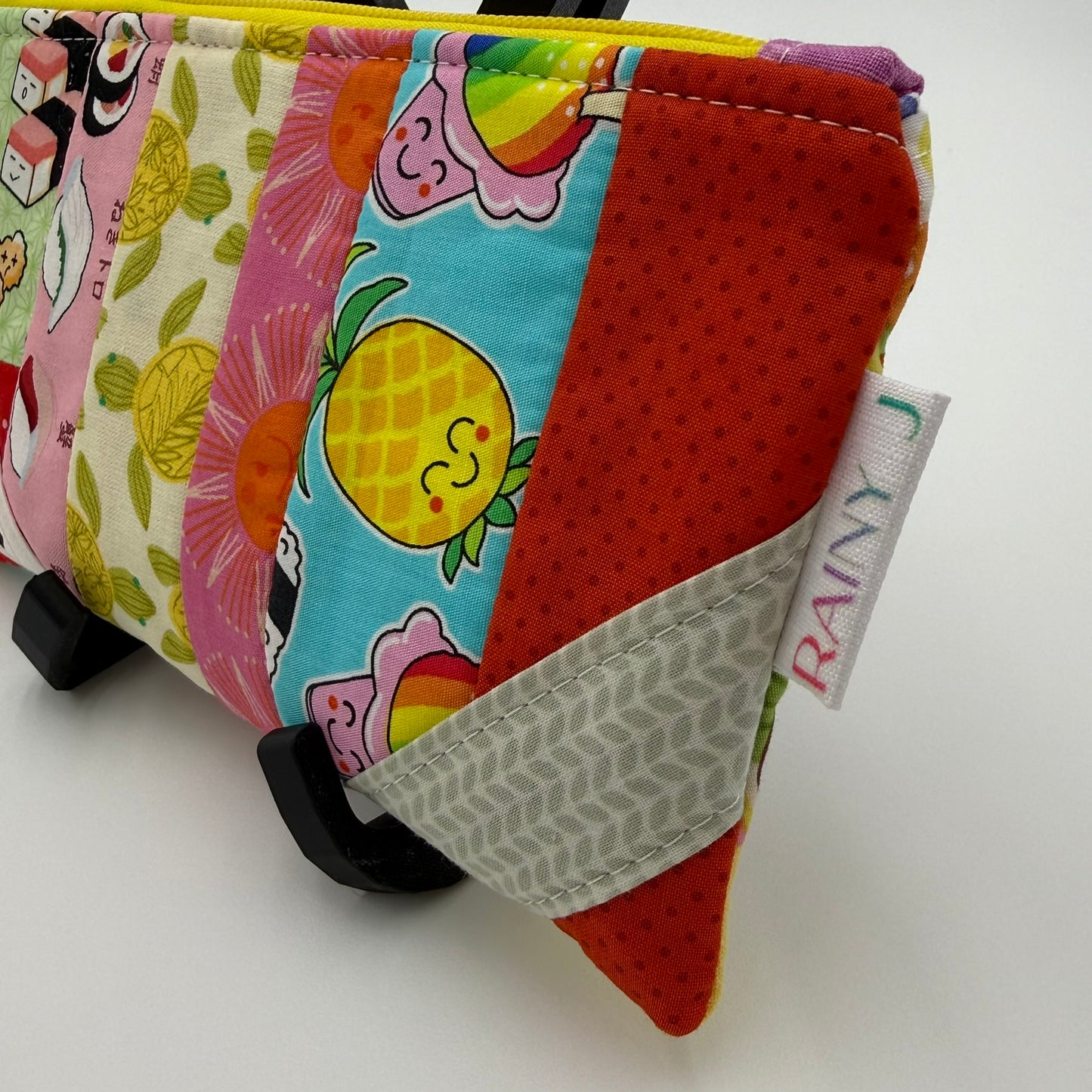 Handmade patchwork quilted zipper pouch with colorful fabric scraps