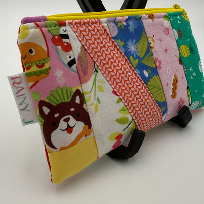 Handmade patchwork quilted zipper pouch with colorful fabric scraps