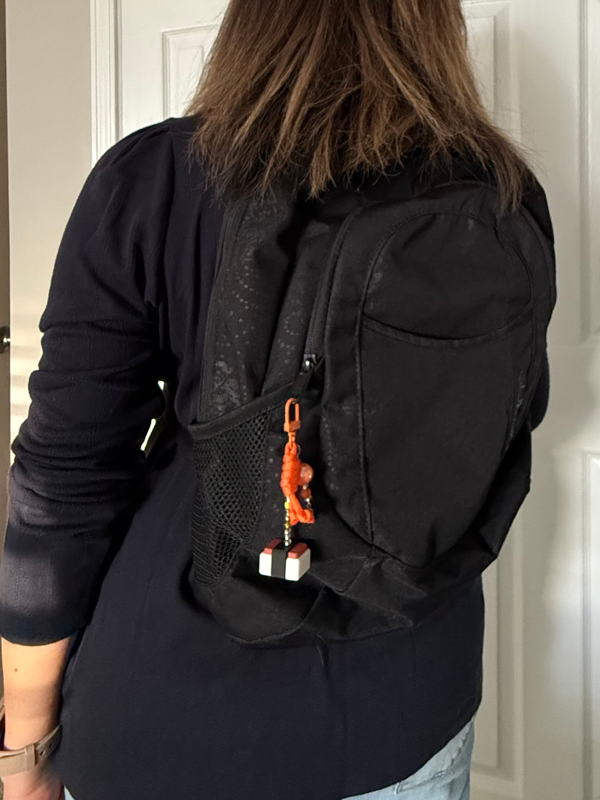 spam musubi bag charm being worn on a backpack