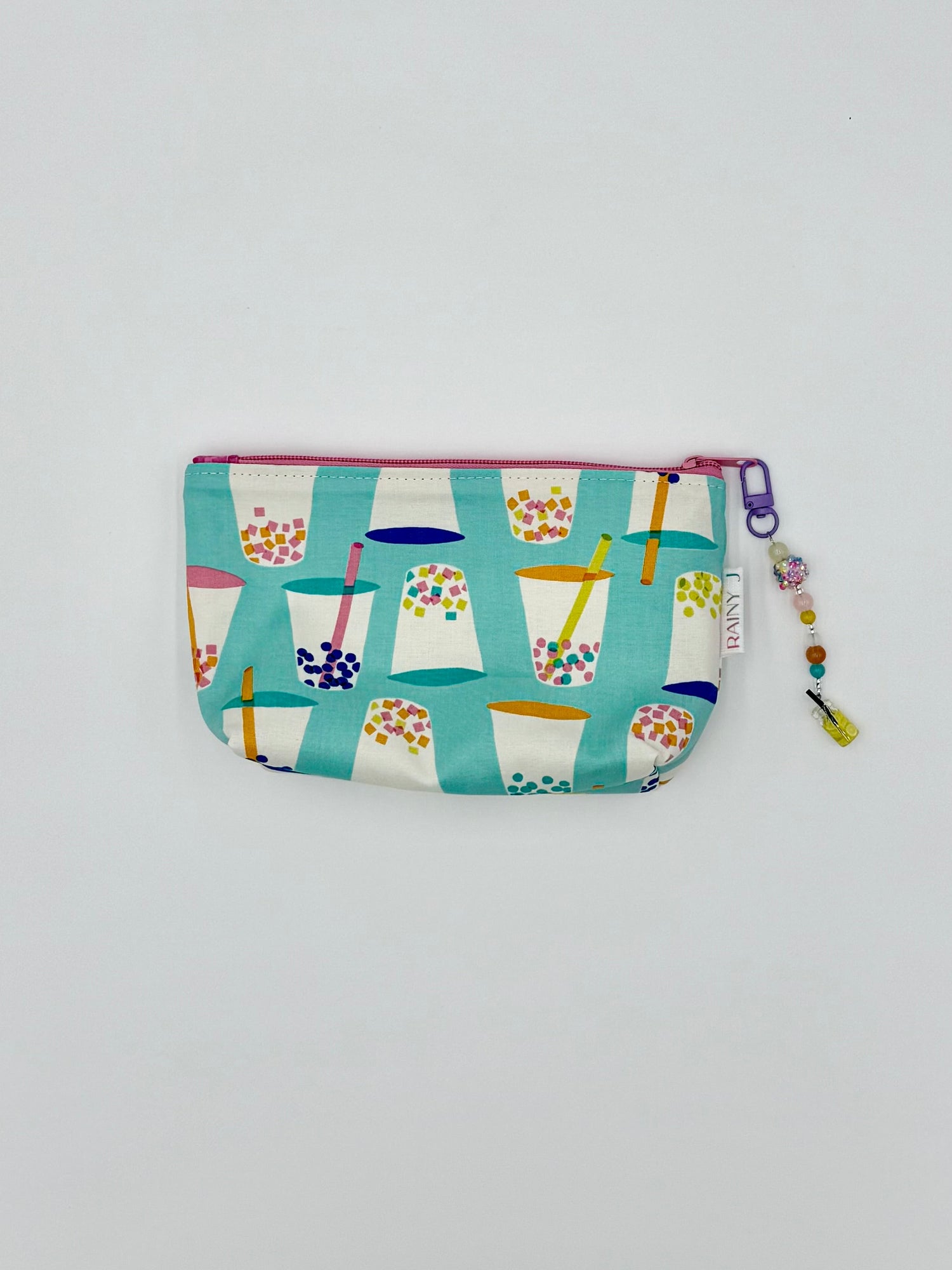 zippered toiletry bag with boba print on an aqua background with a kawaii charm