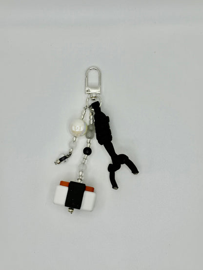 Handmade Spam musubi charm with seaweed wrap and rice details, front view.