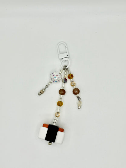 Handmade Spam musubi charm with seaweed wrap and rice details, front view.
