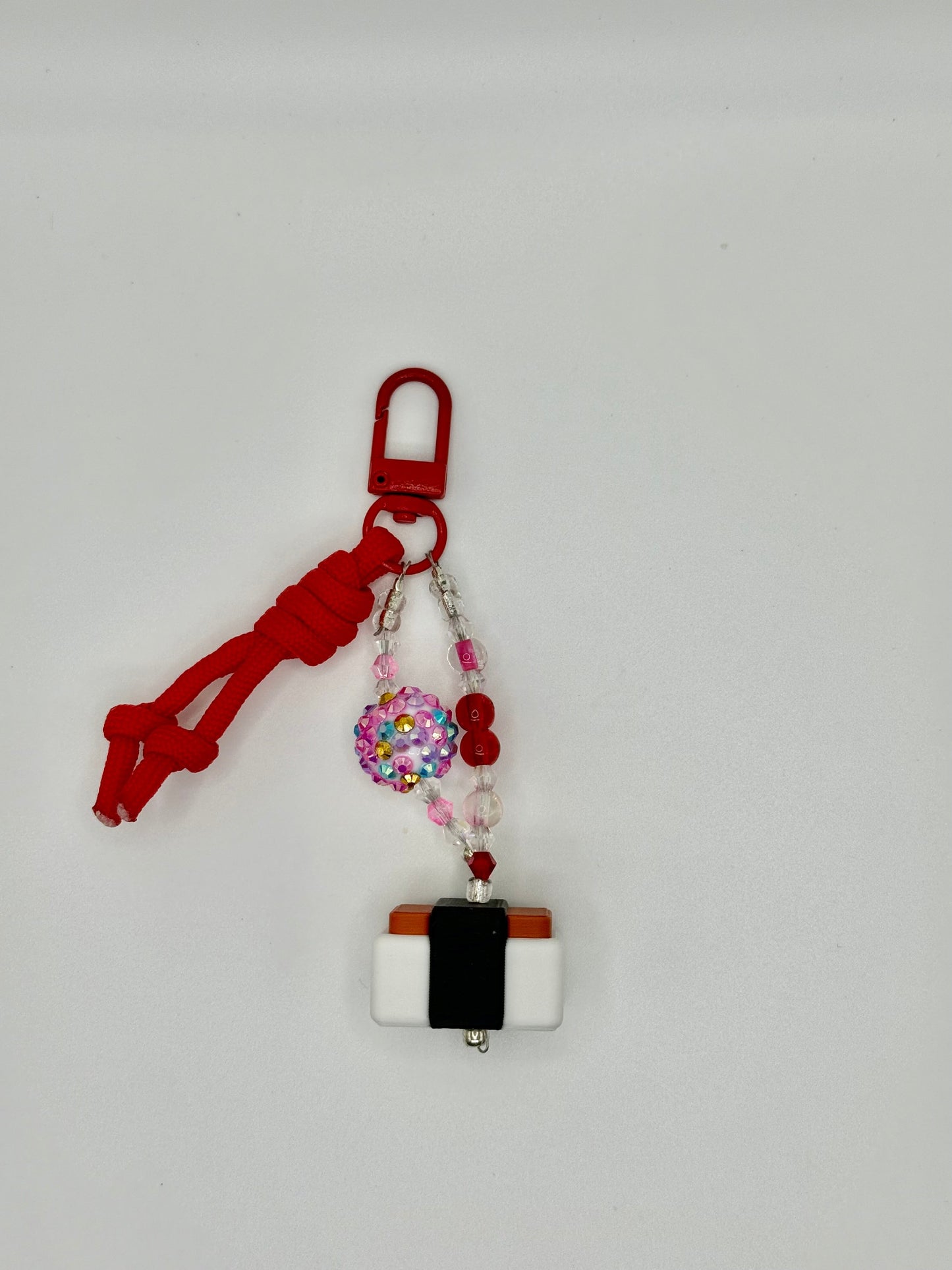Handmade Spam musubi charm with seaweed wrap and rice details, front view